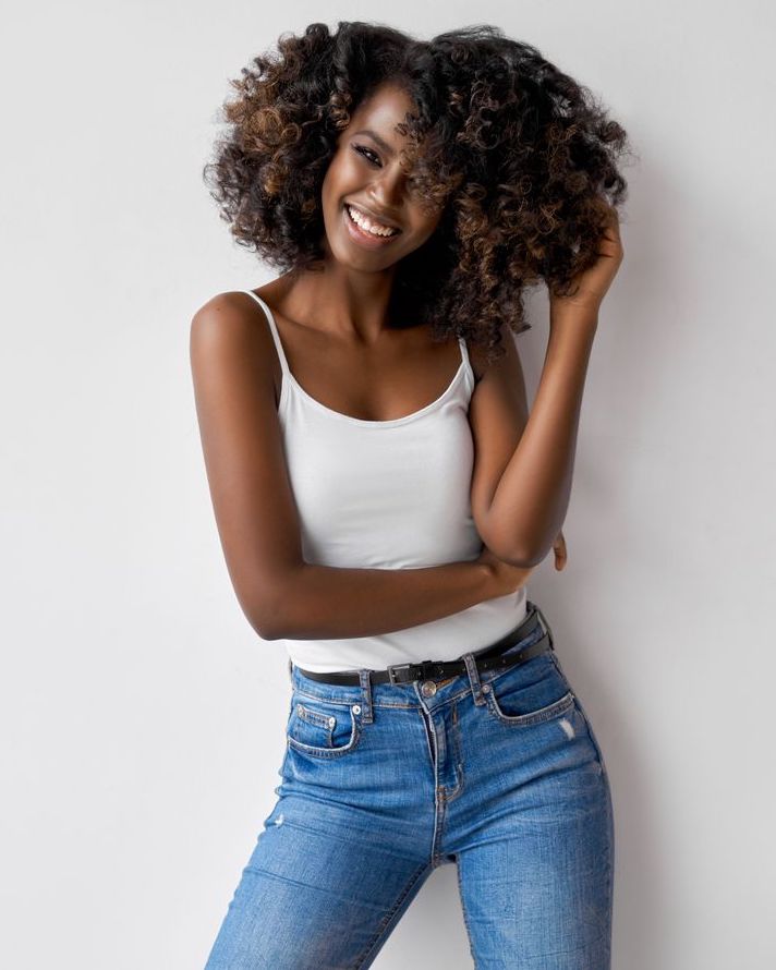 Photo of a slim, happy woman in jeans and white top
